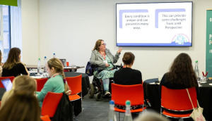 A woman in a wheelchair teaches a class around understanding neurodivergence